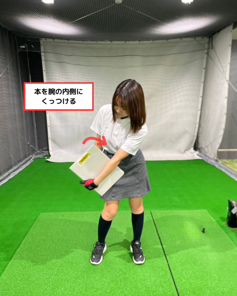 本を腕の内側にくっつける動作